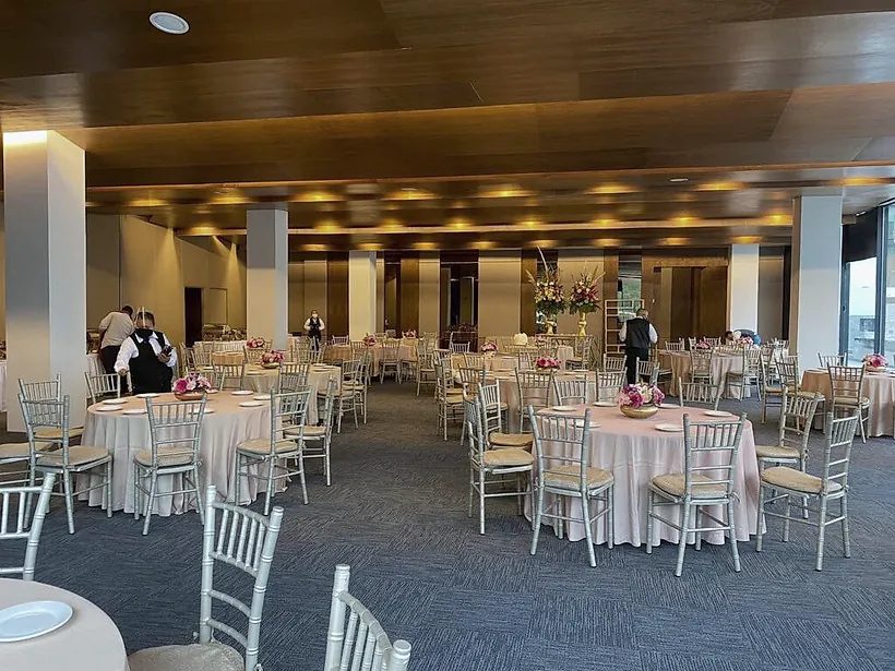 Salón del Club Alpino Chipinque terminado y montado para un evento, con plafón de madera, columnas y alfombra