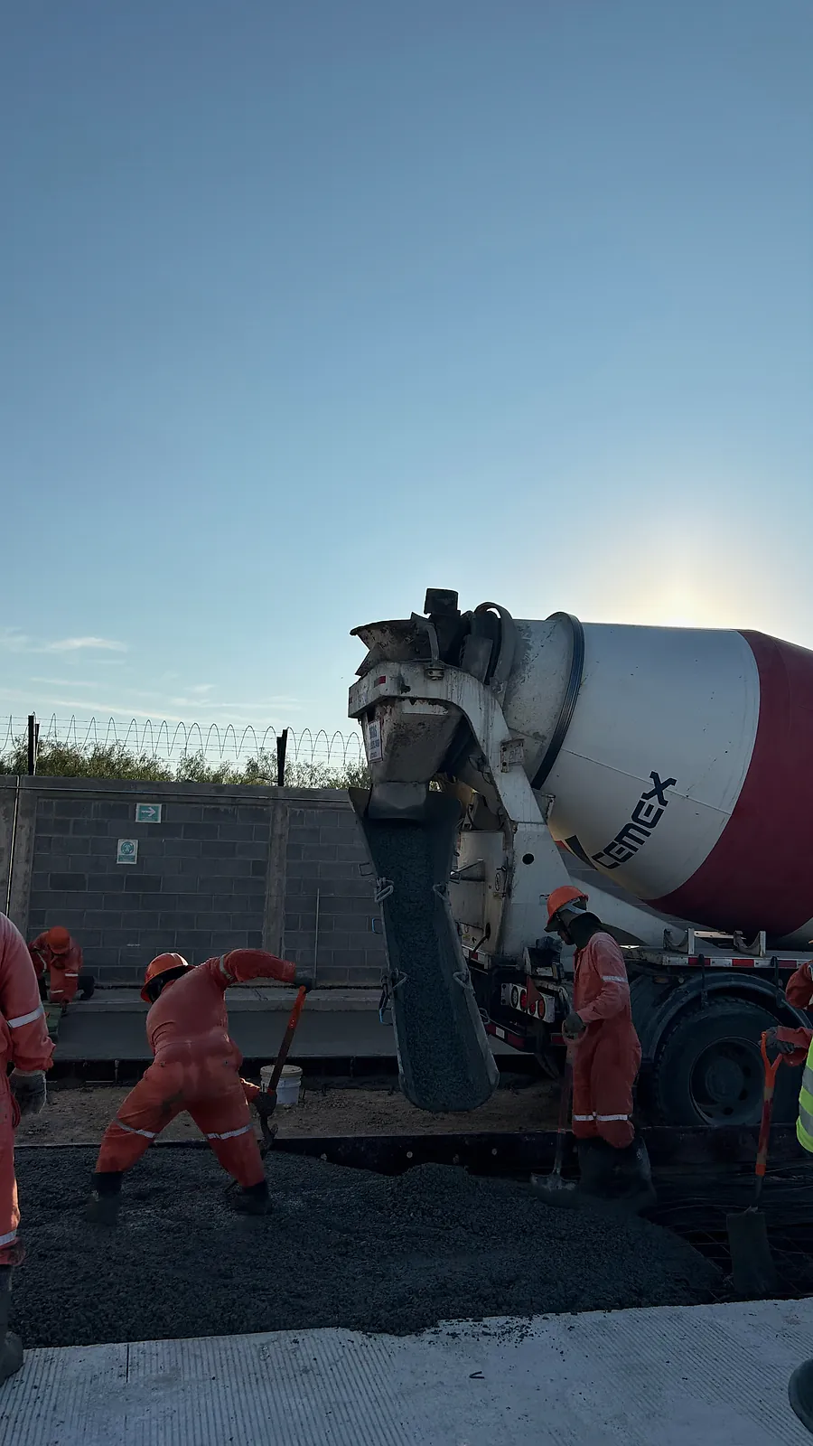 Colado de una vialidad de concreto hidráulico en la Estación Anzalduas: una revolvedora descarga mientras la cuadrilla extiende el concreto