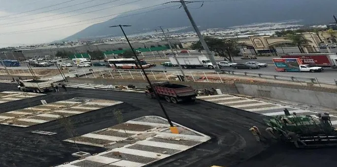 Vista elevada del estacionamiento de Home Depot Lincoln durante el asfaltado, con pavimentadora y camiones de volteo